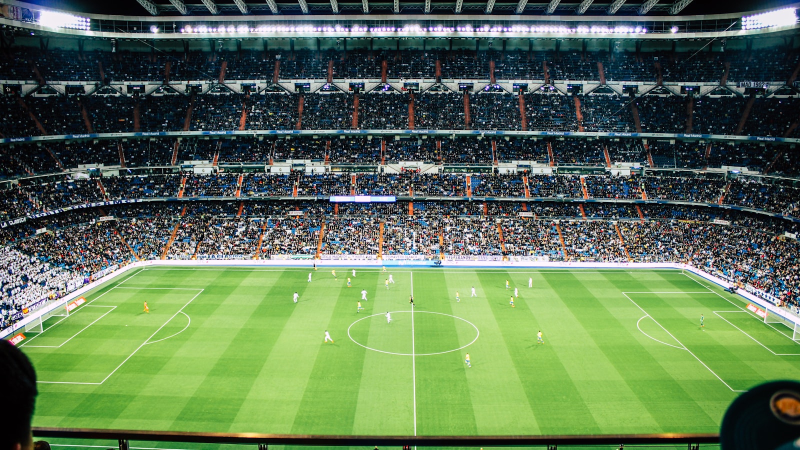 บรรยากาศการแข่งขันฟุตบอลในสนามที่เต็มไปด้วยกองเชียร์